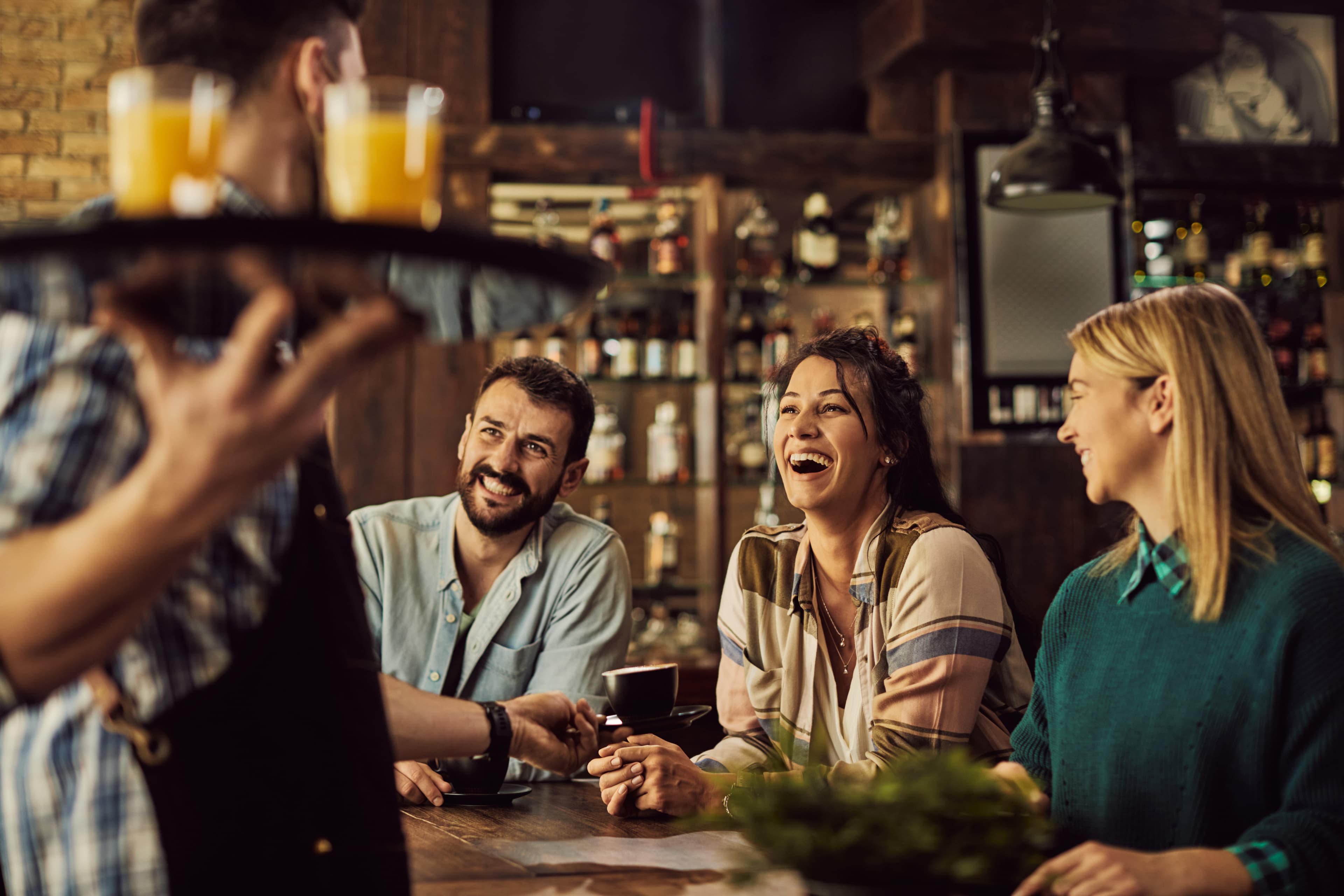Group of guests enjoying drinks in a hotel or restaurant setting, illustrating guest satisfaction and engagement as highlighted in the WhatsApp Hospitality Ebook.